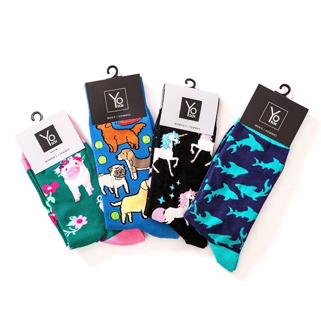 display showing 4 samples of Yo Sox sock designs pig, dogs, unicorn and sharks